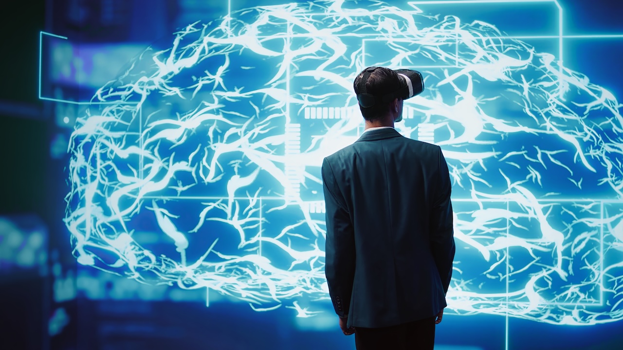 Intelligenza artificiale nel design: uomo con visore VR osserva cervello digitale, simbolo dell’uso dell’IA nei processi creativi.